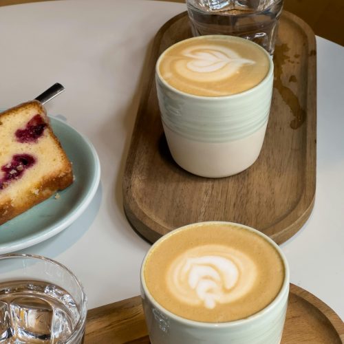 deux tasses à café, verres d'eau et cake aux fruits